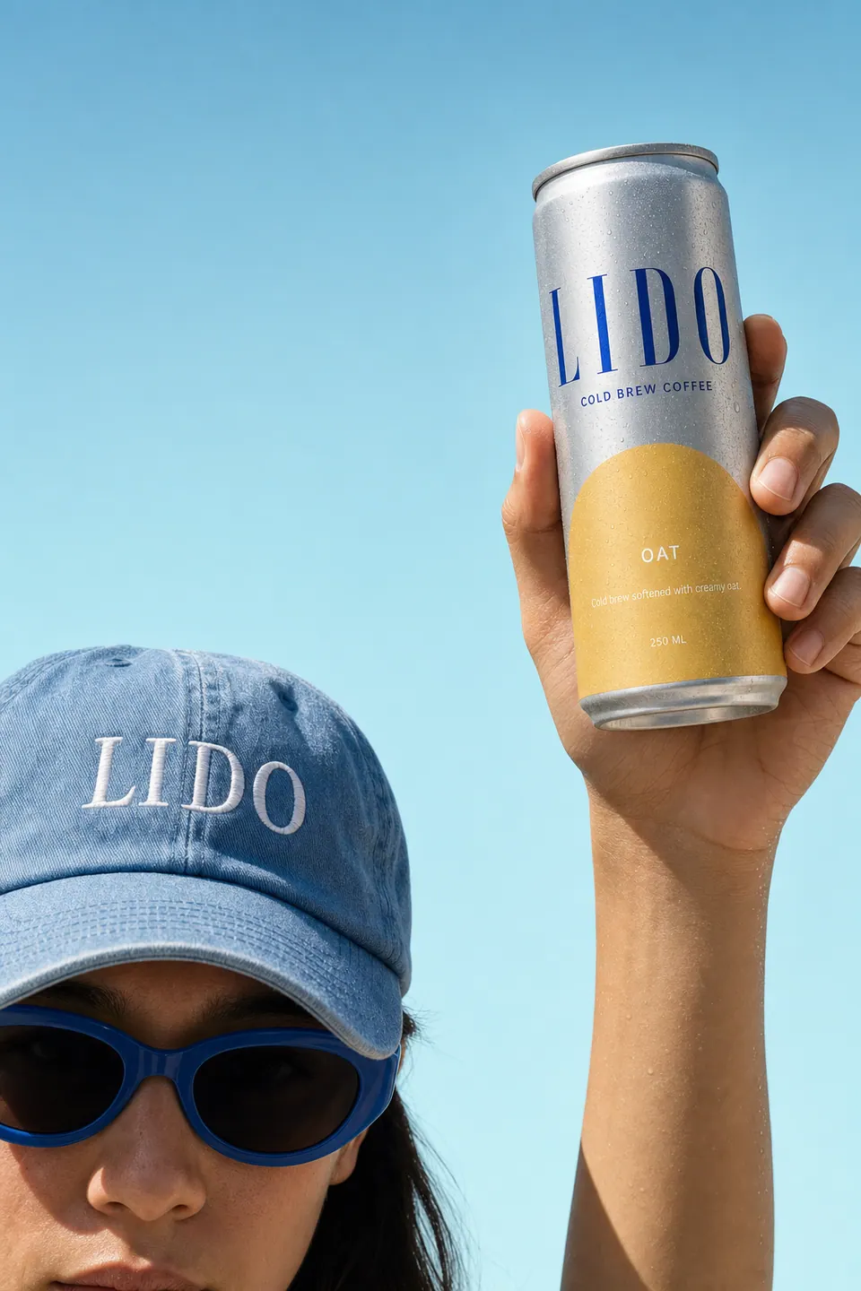 A raised hand holding a LIDO Oat can up to the sky beside the blue cap.