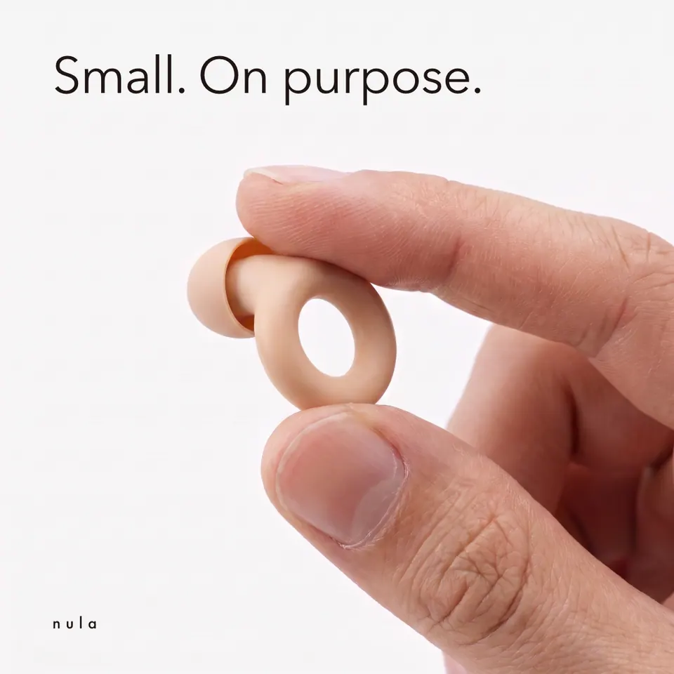 Nula ad: "Small. On purpose." above an earplug held in the hand.