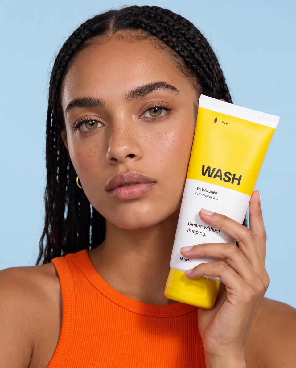 The same model holding a WASH tube against her cheek.
